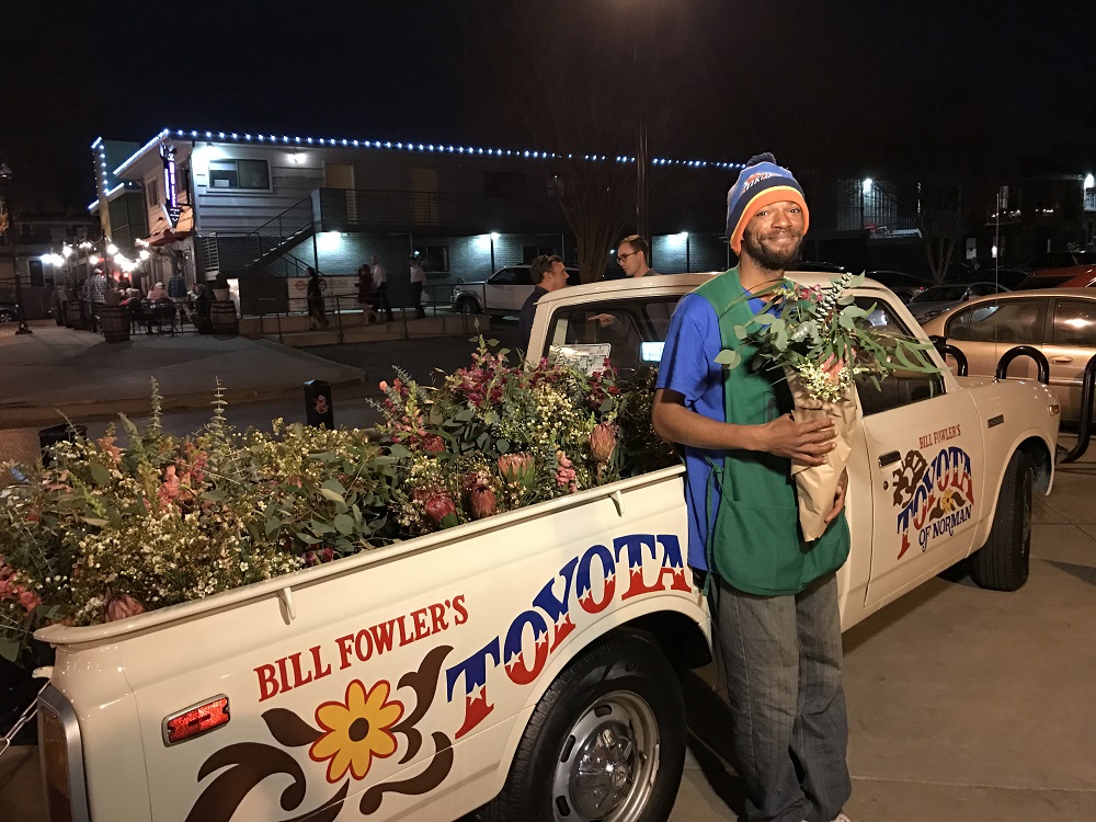 Steven Gage selling bouquets at a night market in Oklahoma City’s Plaza District. Credit: Ranya O’Connor