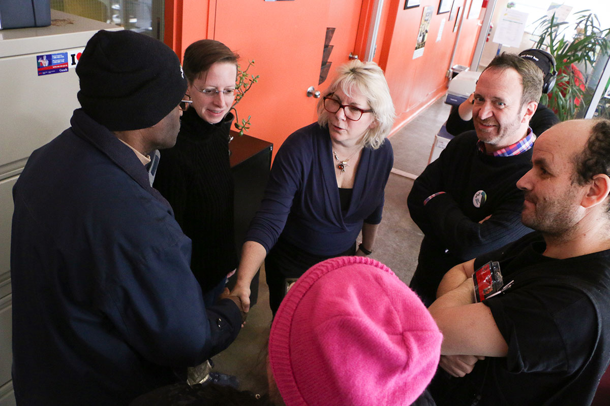 Vendor Mostapha (middle right) introduces visitors to Josée Panet-Raymond, L’Itinéraire’s editor. Photo: Mario Alberto Reyes Alberto.