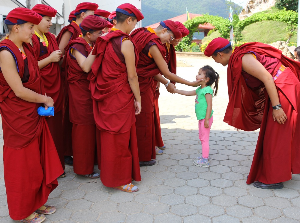 The Drukpa nuns greet a small girl in one of the nearby towns