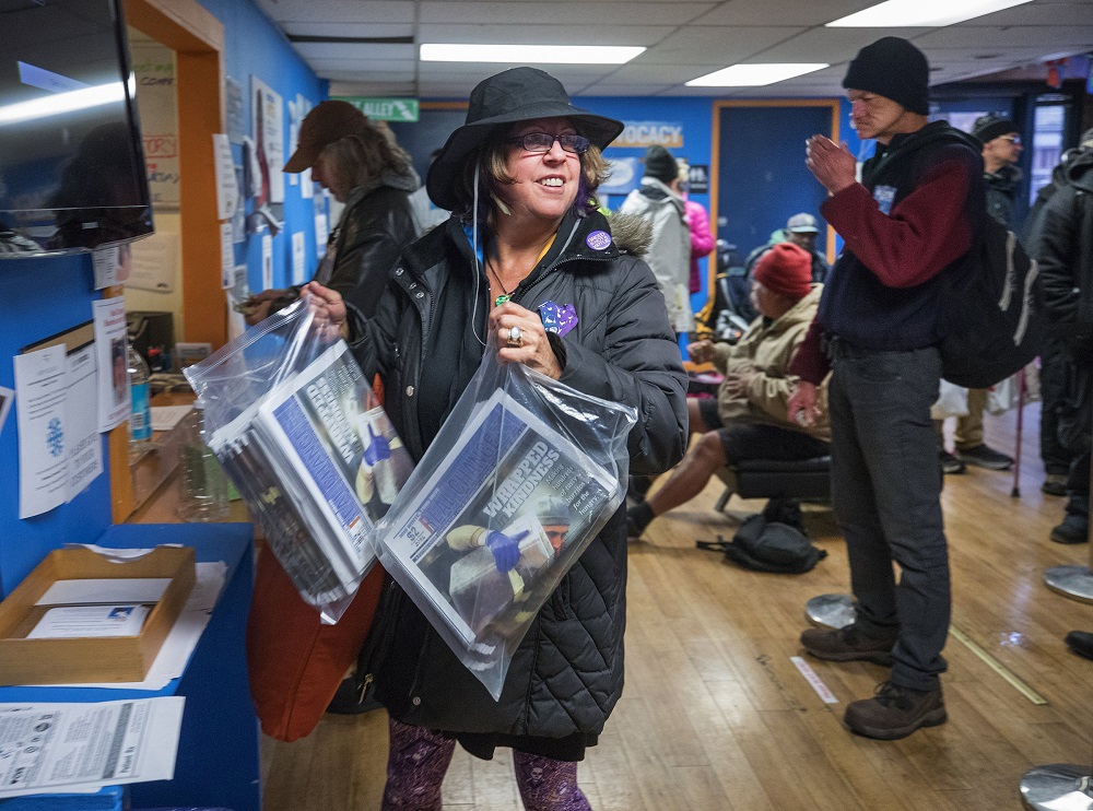 Vendor Susan Russell is a Real Change sales superstar. Here, she’s picking up her weekly supply of newspapers. (Credit: Steve Ringman / The Seattle Times)