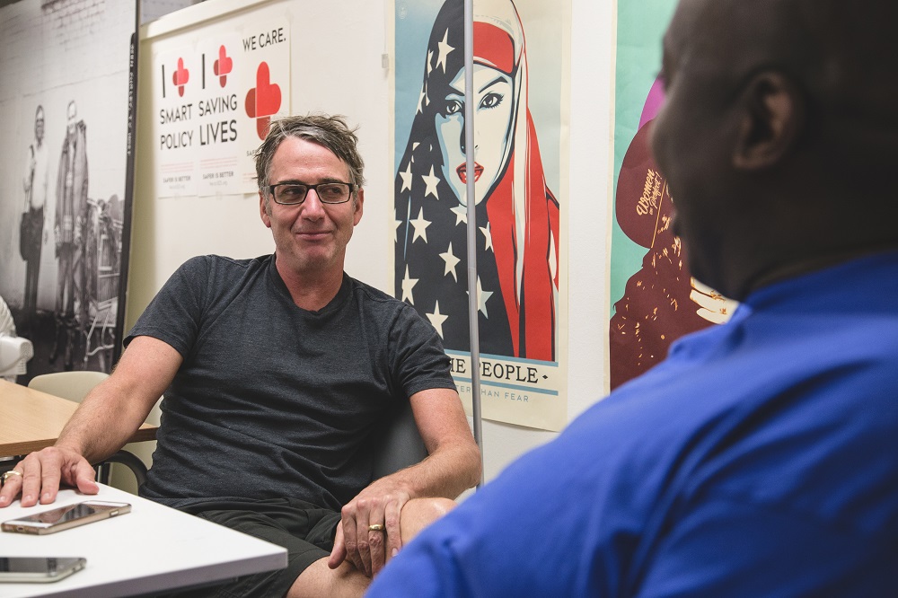 Vendor Darrell Wren chats to Stone Gossard at the Real Change office. (Credit: Matthew S. Browning)