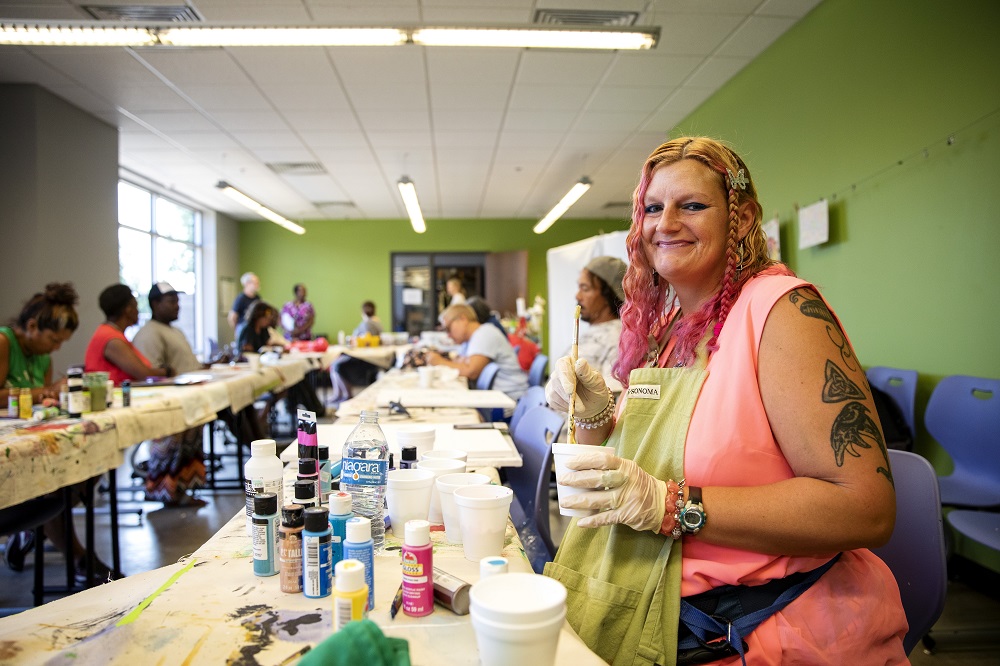 Lauren prepares acrylic paint at the OKC Day Shelter during Fresh StART, a weekly art class offered to people at risk of or experiencing homelessness in Oklahoma City. [Credit: Nathan Poppe]