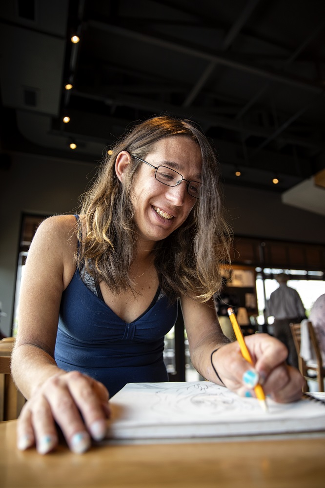 Rin draws at an Oklahoma City coffee shop. Her sketch book is full of original creations and animated pop culture icons. [Credit: Nathan Poppe]