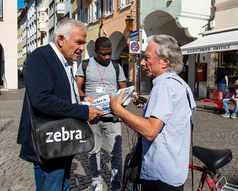 Heiner Oberrauch sells zebra. with vendor David. [Courtesy of zebra.]