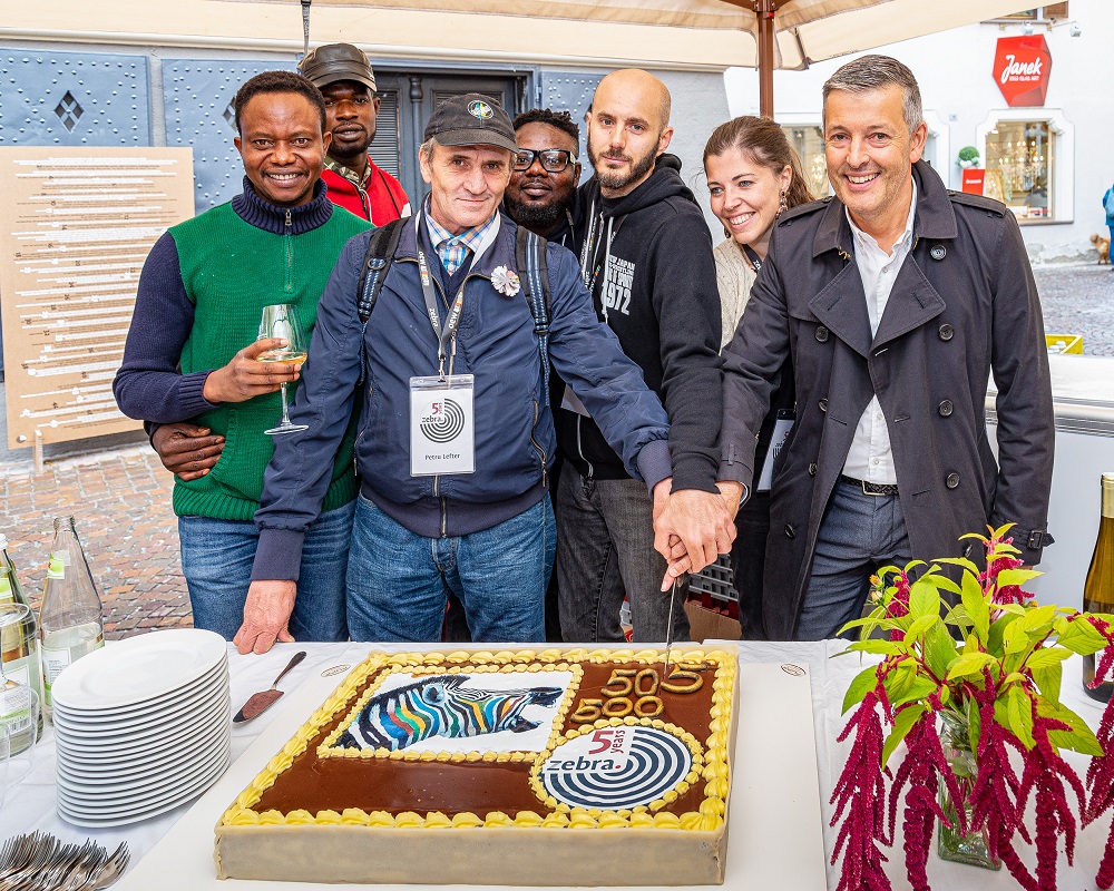 zebra. staff and vendors cut the celebratory cake