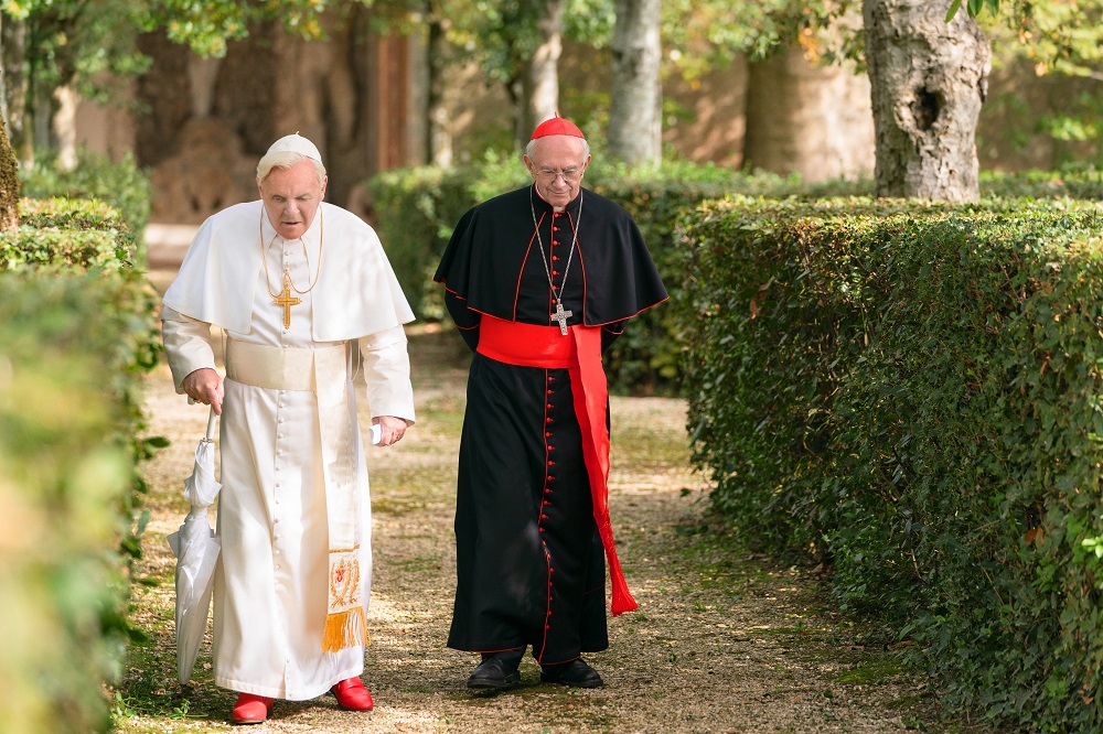 Anthony Hopkins as Pope Benedict XVI (left) and Jonathan Pryce as Pope Francis (right) in The Two Popes. [Image courtesy of Netflix]