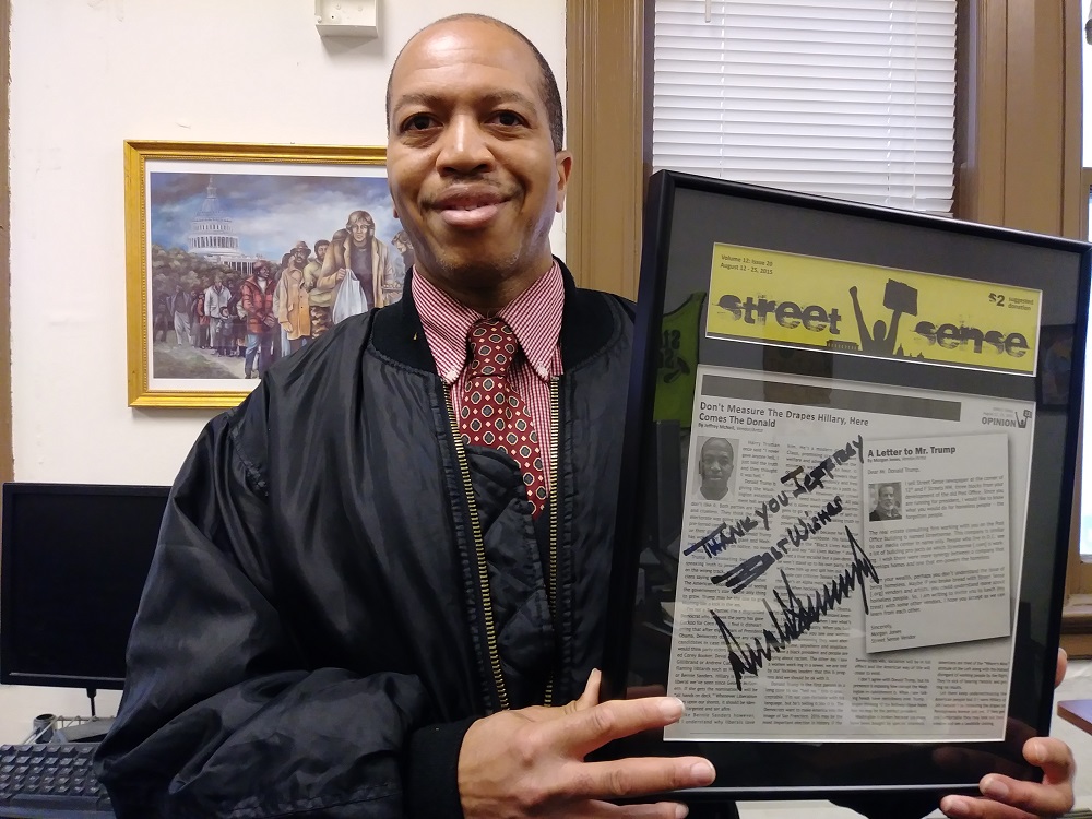 Jeffery with a copy of Street Sense, containing his column, signed by Donald Trump.