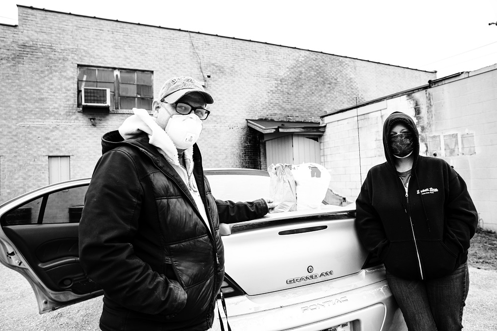 Sam, left, and Jennifer ready food and supplies for an outreach stop near downtown Oklahoma City. They are both employees of The Homeless Alliance in Oklahoma City and spend their days ensuring the homeless community has access to basic necessities. [Credit: Nathan Poppe]