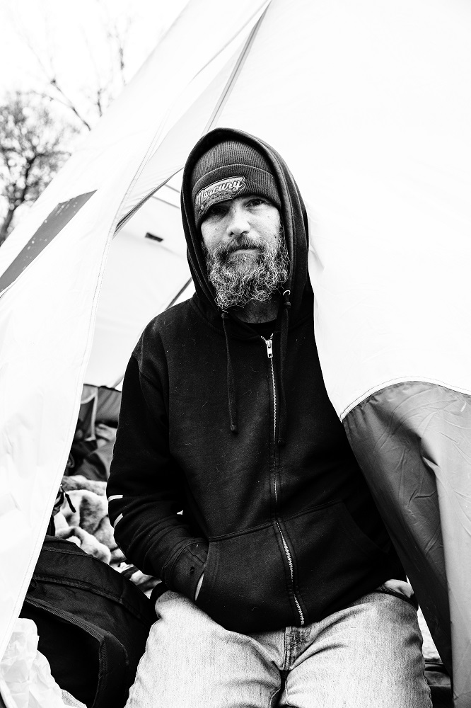 Wes sits inside his tent after receiving donated food and supplies. [Credit: Nathan Poppe]