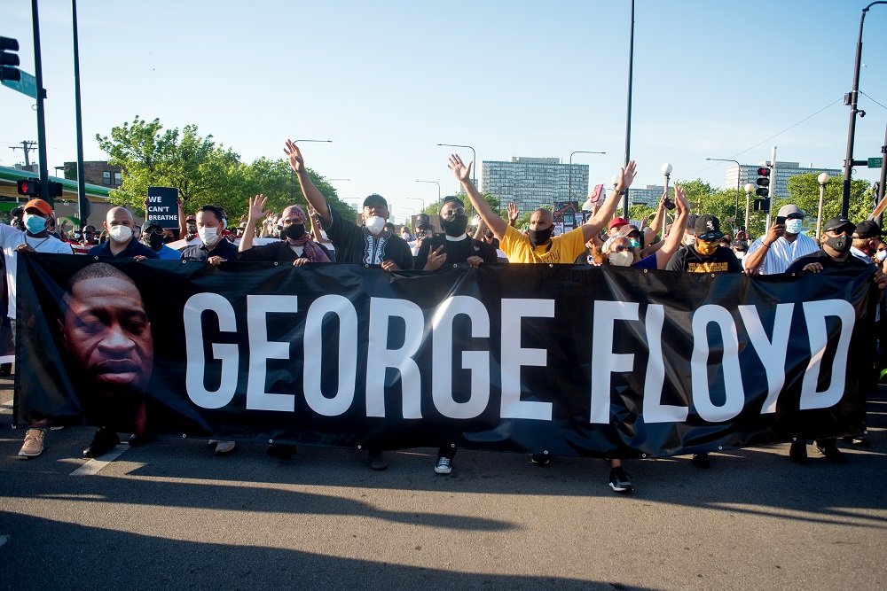 Holding a banner bearing George Floyd's face and name, faith leaders from across the Chicago area marched down Martin Luther King Drive in Bronzeville. [Credit: Kathleen Hinkel/StreetWise]