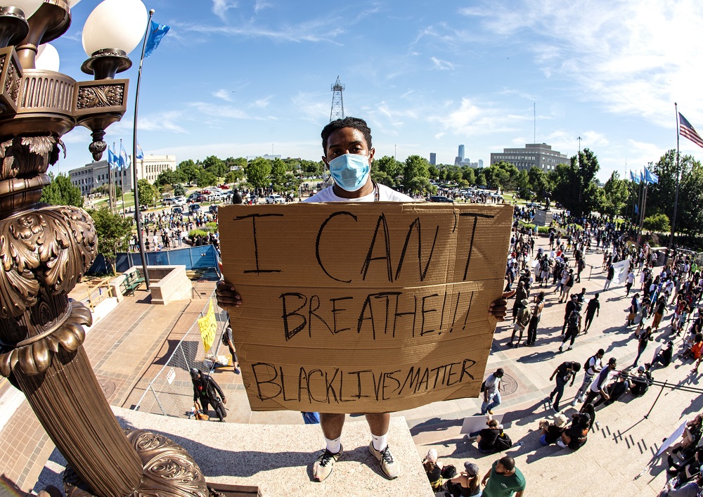 A protestor stands atop the Oklahoma State Capitol building stairs on May 31, 2020. Photo by Nathan Poppe, The Curbside Chronicle.