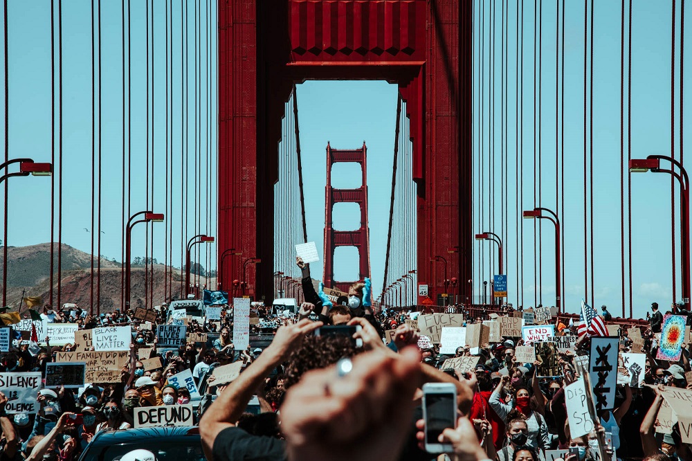 Having been confined to the pedestrian walkways for most of the march, protesters spill into the roadway and halt traffic on the Golden Gate Bridge. [Credit: Kit Castagne]