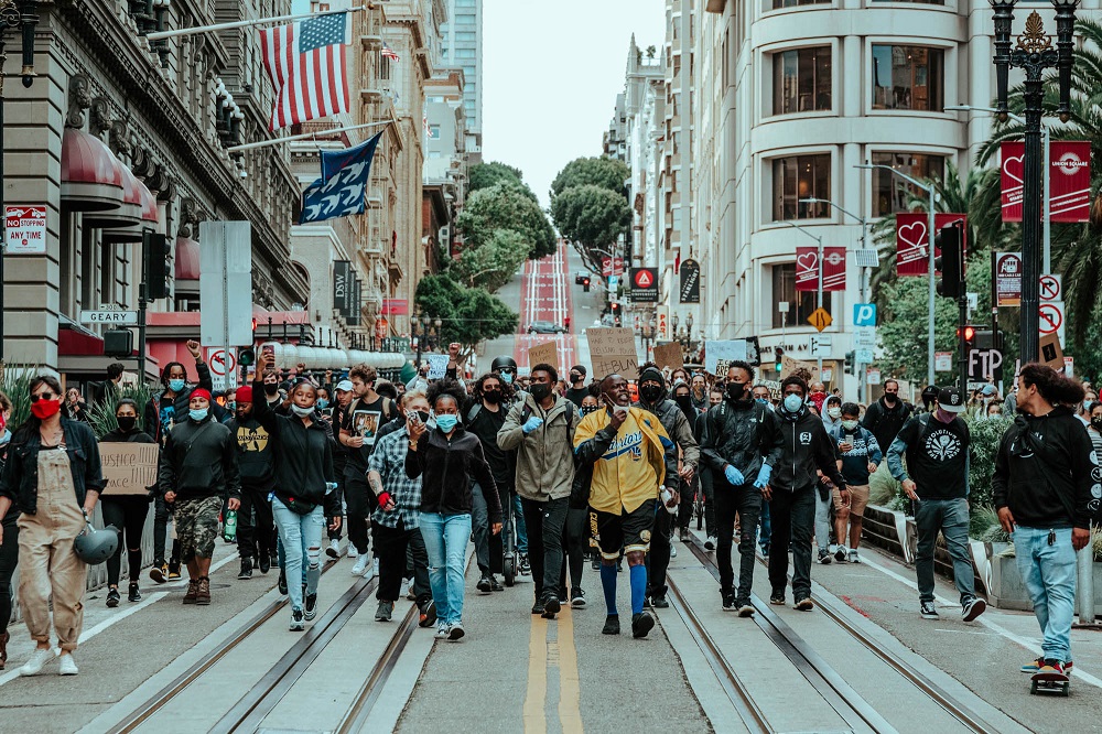 A group of protesters marches down Powell Street. [Credit: Kit Castagne]