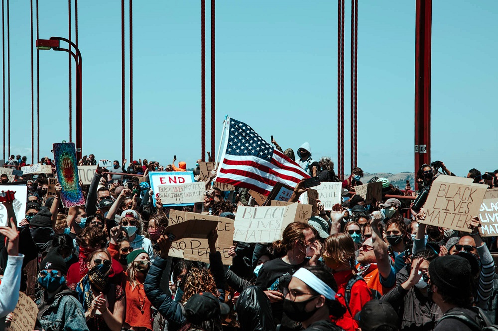 Protesters raise the American flag on the Golden Gate Bridge. [Credit: Kit Castagne]