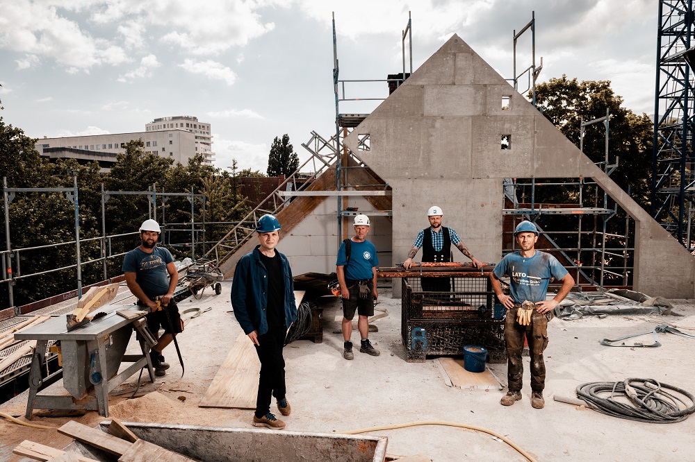 In the photo (L to R): Builder Selim Selimi, Architect Axel Hauschildt, crane driver Fejsal Demiri, foreman Nico Wagner and builder Rezak Suleimani on the roof of the Hinz&Kunzt Building – still lacking the roofing joists! [Photo: Mauricio Bustamante]