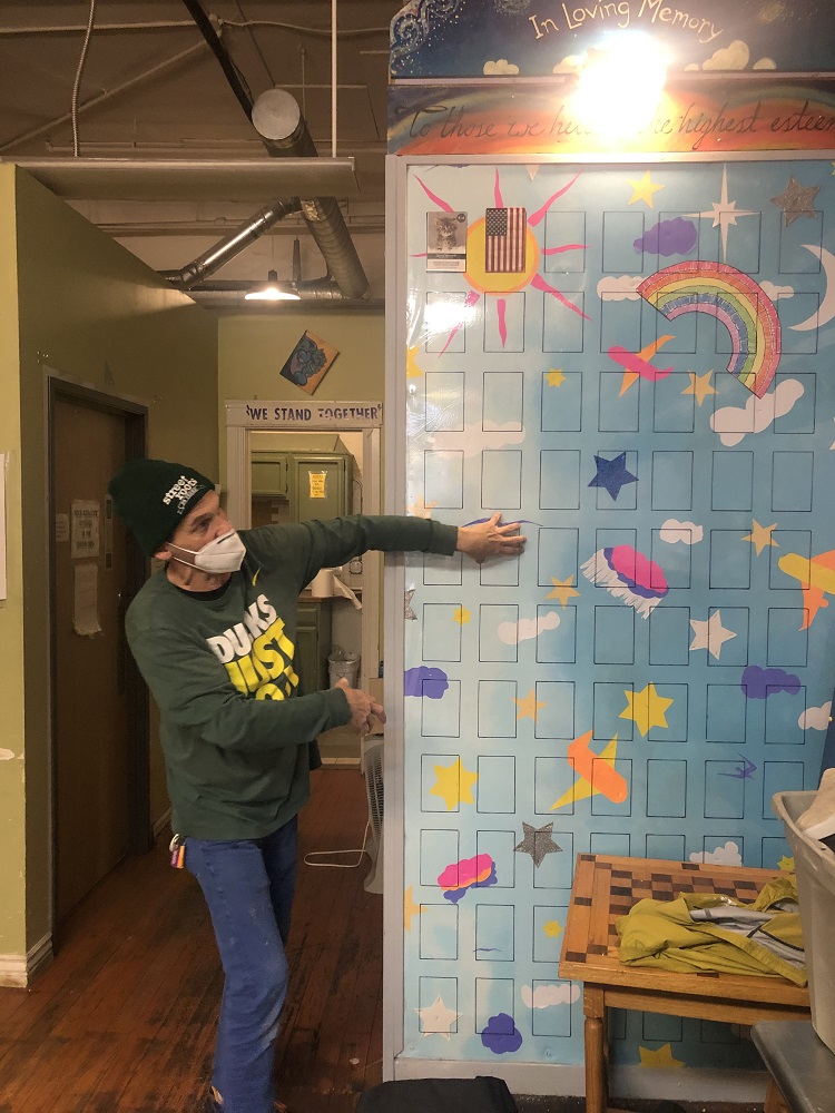 Street Roots vendor Rick Davis working on the memorial wall in the Street Roots office. [Courtesy of Street Roots]