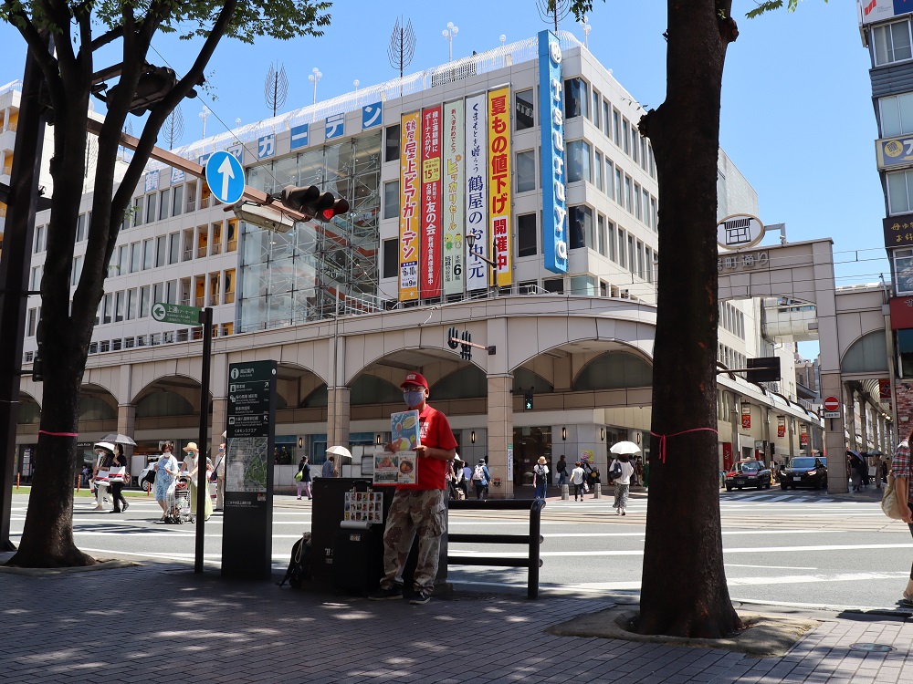 Visible behind him is the long-standing Tsuruya Department Store. [Credit: Yakuwa Kayoko]