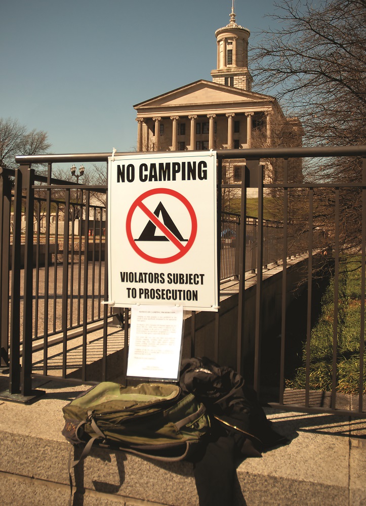Local Activists put up a sign in protest of the “No Trespassing” sign in front of the Tennessee State Capitol. It reads, “Sleeping is Not a Crime.” Photo by Alvine.